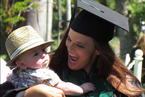 Emily Grant in cap and gown with baby